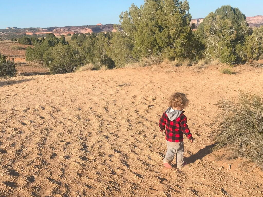 A toddler walks in the dirt at Canyonlands National Park.