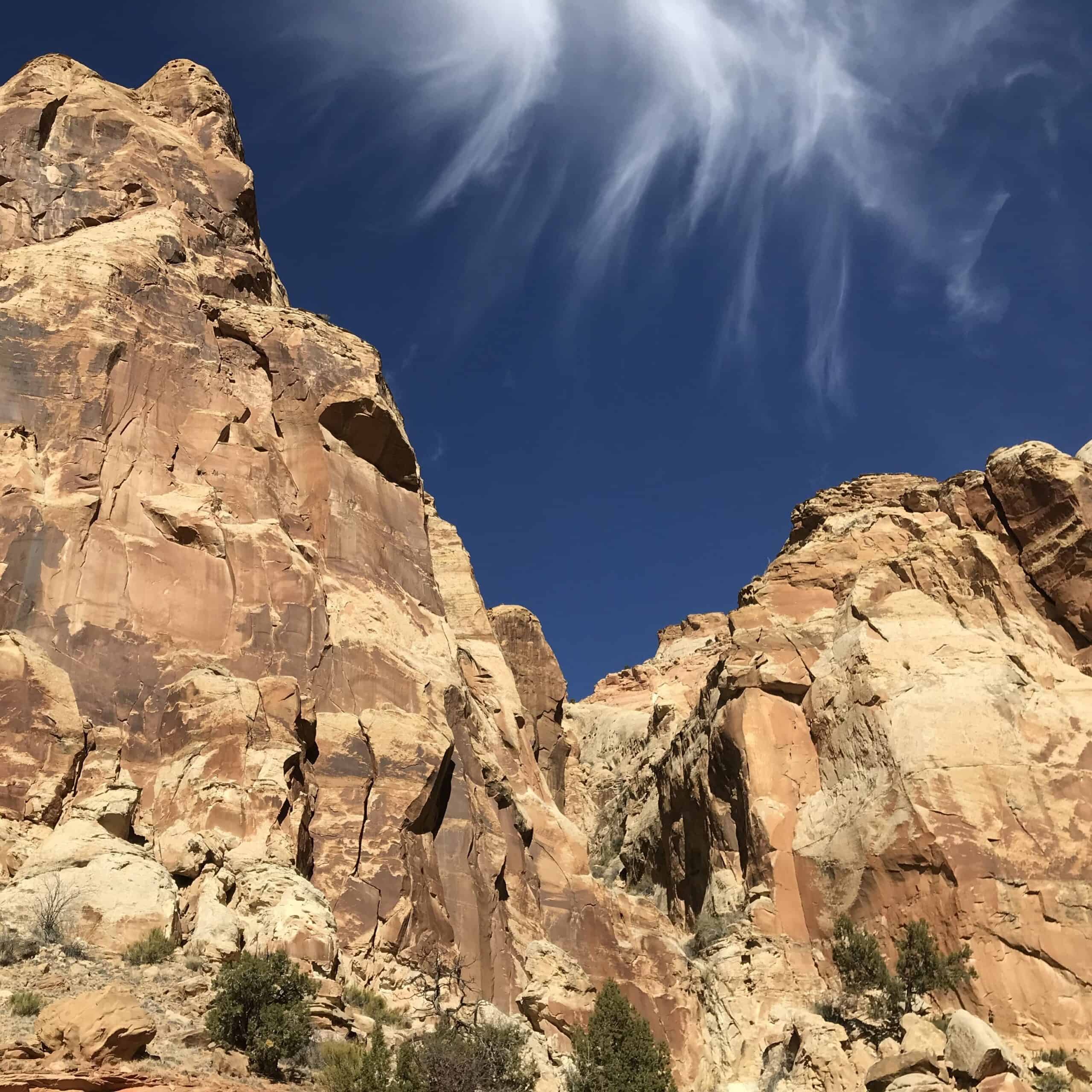 What is the National Park with the fewest crowds? This photo depicts a blue sky and rock cliffs on a quiet day at Capitol Reef.