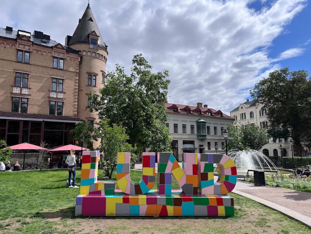 A colorful sign on the grass in front of some stately buildings in the heart of Lund, Sweden, which is a short train ride away from Copenhagen.