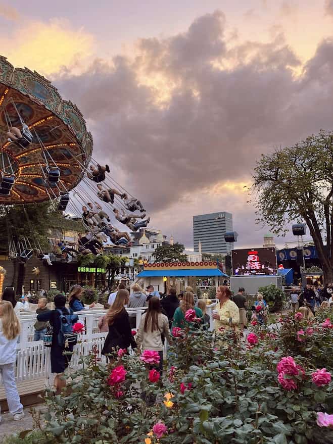 A colorful photo of the swings at Tivoli Gardens with roses in the foreground.