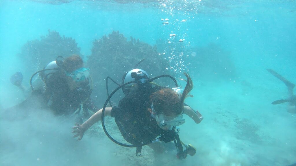 Two people underwater scuba diving in Moorea.